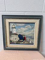 Overall front view of the wooden carved picture frame with coastal lighthouse artwork.