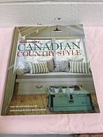 Front cover of Canadian Country Style hardcover book with porch seat and decorative pillows, turquoise trunk table.