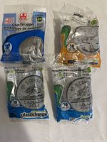 Four packages of Selectum PlasticChange coin wrappers, sealed, each pack containing 10 wrappers, placed on a surface for display.