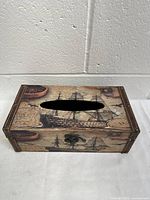 Napkin holder top view showing oval cutout and vintage ship design with nautical elements.