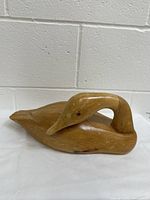 Side angle of wooden carved Canada goose decoy showing curved neck and body detail.