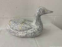 Side view of the wooden duck decoy showing the painted feather details and shape.