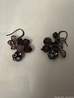Front view of pair of "BRUNCHES" earrings showing clusters of purple beads and rhinestones on wire hooks.