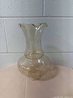 Full view of the beige glass lampshade showing its bulbous midsection and ruffled top edge