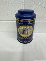 Front view of the blue metal tea tin with gold accents and vintage illustration showing brand and product name.