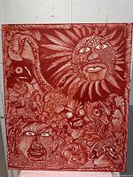 Full view of the red and white abstract painting showing faces and sun motifs on canvas.