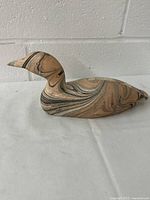 Side view of the plaster duck decoy showing marbled pattern and shape details.