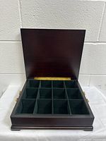 Top view of open tea chest showing 16 compartments lined with dark velvet.