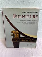 Front cover of The History of Furniture book showing the title, subtitle, and author with image of a classical furniture element.