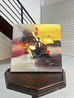 Full view of the abstract acrylic painting showing bold strokes in yellow, black, white, red, and blue tones on canvas.