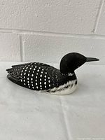 Side angle of the wooden loon figurine showing detailed carving and paint work on wings and head.