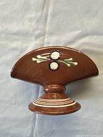 Top view of the brown glazed ceramic napkin holder with folk-style white and green floral painting.