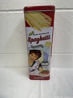 Front view of tall rectangular vintage spaghetti tin showing colorful retro design with spaghetti and woman serving pasta.