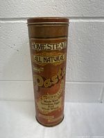 Front view of vintage Homestead All Natural Pasta tin canister showing the label with product information and visible rust and wear.
