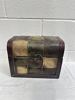 Closed vintage wooden hard case with leather patchwork exterior and front clasp lock