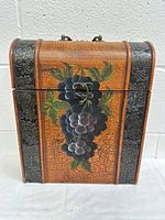 Front view of vintage wooden wine case showing painted grape cluster and metal latch.