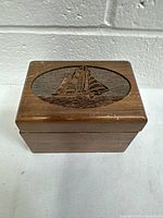 Closed wooden box showing laser cut sailboat design on lid