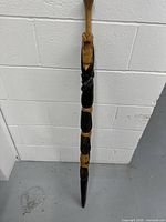 Full-length view of the wooden cane showing overall carvings and shape.