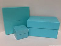Three Tiffany & Co. boxes arranged against white background showing sizes and color