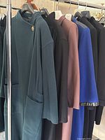 Rack shot showing all six wool coats in various colors hanging on a clothing rack