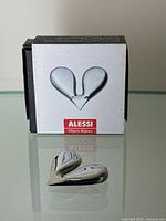 Nut splitter placed in front of its box showing the Alessi branding and product.