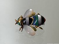 Top-down view of brooch showing overall design, gemstone stripes, and wings.