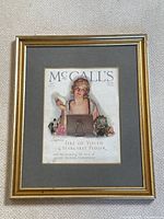 Gold framed McCall's magazine cover print hung on a wall, showing full print and frame.