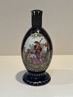 Front view of the dark blue oval porcelain bottle with painted romantic courting scene and gold trim