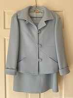 Front view of powder blue wool jacket and matching skirt hanging