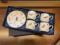 Four coffee cups and one saucer in original box with blue satin lining