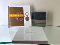 Full lot items including gift set box, metal notebook, keychain, and four sealed scented cushion boxes
