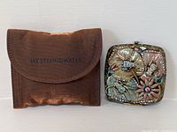 Compact mirror closed, front view showing enamel and rhinestone design