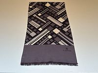 Scarf laid flat showing full geometric print and fringed edge