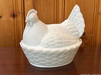 Front and side views of the milk glass hen dish showing detailed feather texture and basket weave pattern on the base