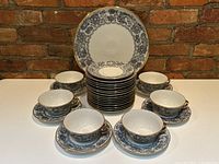 Full set arranged with platter behind, stack of plates and six cups on matching saucers