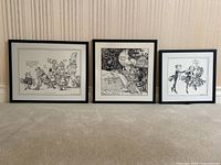 Three framed political cartoons displayed side by side on a carpeted floor against a wallpapered wall