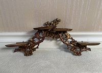 Front view of two gilt wood carved wall shelves stacked vertically