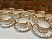 Front row of teacups and saucers showing pattern and count