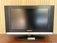 Front view of Samsung 23-inch HDTV monitor showing black bezel, Samsung logo, rectangular base stand, and reflective screen surface.