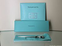 Pen laid out on Tiffany blue pouch with box and polishing cloth behind