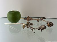 Pair of sterling silver rose stems displayed with green apple for scale