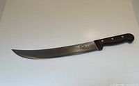 Long curved carving knife with wooden handle and metal rivets, blade shows Victorinox logo.