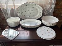 Group shot of six photographed pieces (platter, drainer with insert, two bowls, square and round trivets)