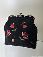 Front view of the purse showing embroidered roses and beadwork with metal frame
