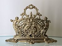 Front view showing open lattice design with cherubs and central bird motif