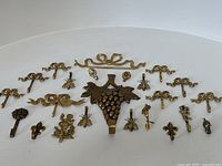 Overhead overview of all brass picture hanger hooks arranged on white background