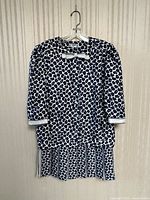 Full front view of jacket and skirt ensemble on hanger against neutral background