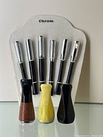 Three cigar holders in front of the cigarette holders, showing different base colors and materials (wood, yellow marbled, black).