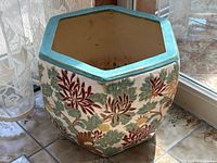 Front view of hexagonal planter showing embossed floral design