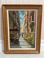 Overall front view of framed oil painting showing full market street scene.
